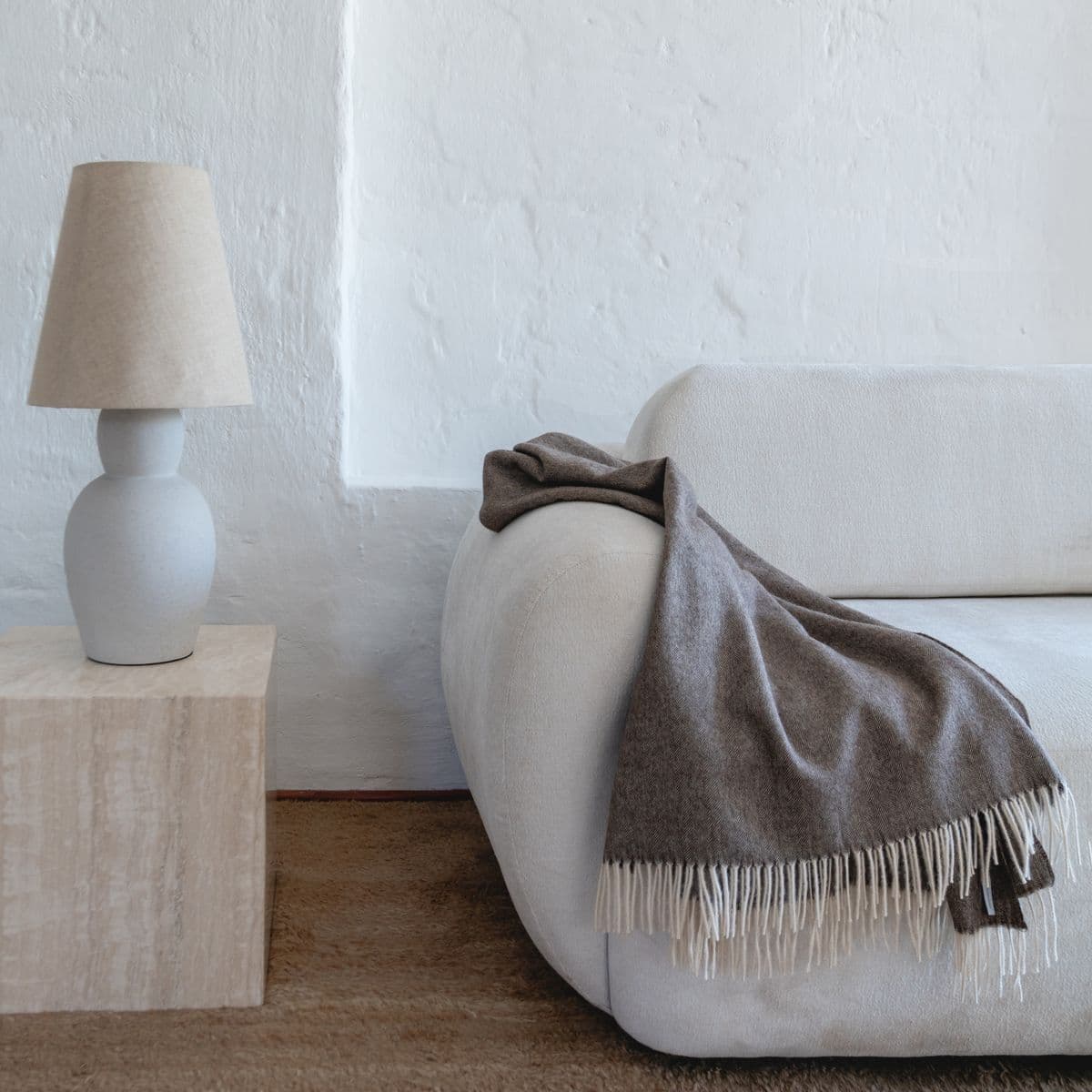 Baby Alpaca throw in a room setting, showing the woven texture and the fringes
